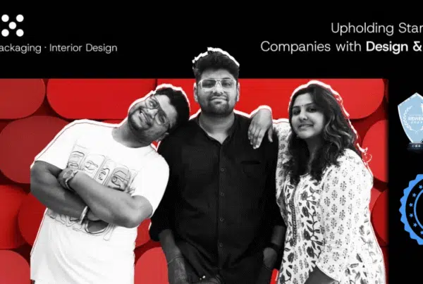 Professional team photo of The Factor X (TFX), a branding, packaging, and interior design agency based in Indore. The image features the three core team members against a bold, red geometric background. Text highlights their mission: 'Upholding Startups and Companies with Design & Strategy.