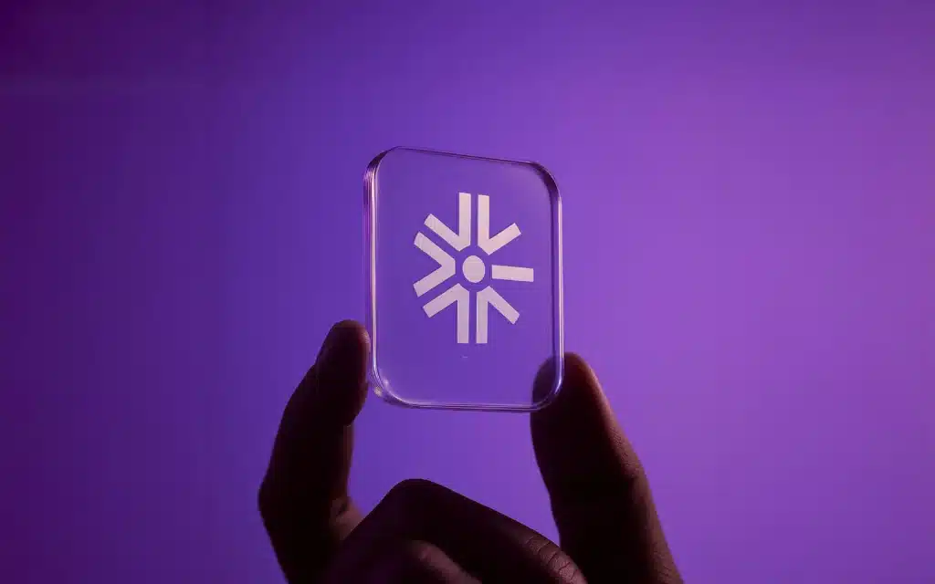 Acrylic glass card with Build with Gen AI symbol held by hand, tactile logo mark for premium branding, emboss and sticker applications, packaging seal and label readiness.